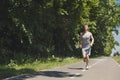 Young man jogging on treadmill in park, copy space