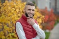 Joyful handsome young man touching his beard