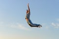 Young man in a jump against a blue sky Royalty Free Stock Photo