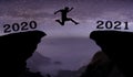 A young man jump between 2020 and 2021 years over night sky with stars and through on the gap of hill  silhouette evening colorful Royalty Free Stock Photo