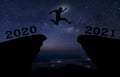 A young man jump between 2020 and 2021 years over night sky with stars and through on the gap of hill  silhouette evening colorful Royalty Free Stock Photo