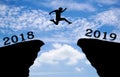 A young man jump between 2018 and 2019 years over the sun and through on the gap of hill silhouette Royalty Free Stock Photo