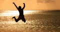 Young man jumping on the beach at sunset Royalty Free Stock Photo