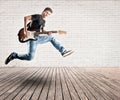 Young man jumping with electric guitar Royalty Free Stock Photo