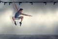Young man jumping in front of gray wall Royalty Free Stock Photo