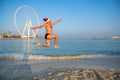 young man jumping high on the beach wearing a santa hat Royalty Free Stock Photo