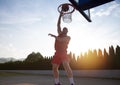 Young man jumping and making a fantastic slam dunk playing stree Royalty Free Stock Photo