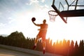 Young man jumping and making a fantastic slam dunk playing stree Royalty Free Stock Photo