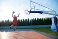 Young man jumping and making a fantastic slam dunk playing stree Royalty Free Stock Photo