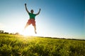 Young man jumping on meadow with dandelions Royalty Free Stock Photo