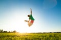 Young man jumping on meadow with dandelions Royalty Free Stock Photo