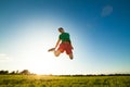 Young man jumping on meadow with dandelions Royalty Free Stock Photo