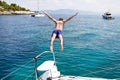 Young man jumping from a sailing boat. Royalty Free Stock Photo