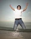 Young man jumping by the sea shore Royalty Free Stock Photo