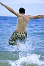 Young man jumping into sea water Royalty Free Stock Photo