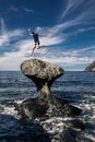 Young man is jumping on stone, Kannesteinen, Norway Royalty Free Stock Photo