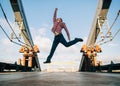 Young man jumping at the urban bridge