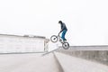 Young man jumps on a BMX bike along the stairs. Bmx freestyle on the background of the urban landscape. BMX concept Royalty Free Stock Photo