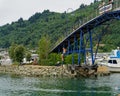 Young man jumps off the Marina footbridge into the sea beneath, while onlookers film the jump. Picton Marina, Marlborough Sounds, Royalty Free Stock Photo