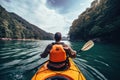 Young man kayaking on the lake in the mountains. Active lifestyle concept, A persons rear view of enjoying an eco friendly Royalty Free Stock Photo