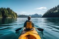 Young man kayaking on a lake in the mountains of active and healthy lifestyle, A person\'s rear view enjoying an eco- Royalty Free Stock Photo