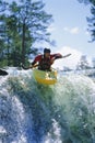 Young man kayaking on waterfall