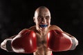 The young man kickboxing on black with kapa in mouth Royalty Free Stock Photo