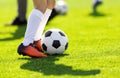 A young man kicking a football outdoors. Young football players Royalty Free Stock Photo