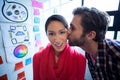 Young man kissing female colleague Royalty Free Stock Photo