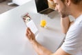 young man at kitchen table with juice and laptop using digital tablet with foursquare