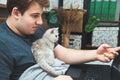 Young man with kitten working at his laptop Royalty Free Stock Photo