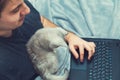 Young man with kitten working at his laptop Royalty Free Stock Photo