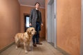 Young man with labrador dog in coat standing in hallway and waiting elevator Royalty Free Stock Photo