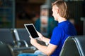 Young man with laptop at the airport while waiting Royalty Free Stock Photo