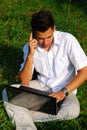 Young man with laptop on the grass Royalty Free Stock Photo