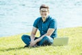 Young man with laptop outdoor sitting on the grass Royalty Free Stock Photo