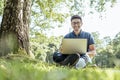 Young man with laptop outdoor sitting on the grass Royalty Free Stock Photo