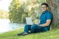 Young man with laptop outdoor sitting on the grass Royalty Free Stock Photo