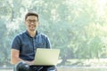 Young man with laptop outdoor sitting on the grass Royalty Free Stock Photo