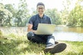 Young man with laptop outdoor sitting on the grass Royalty Free Stock Photo