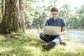 Young man with laptop outdoor sitting on the grass Royalty Free Stock Photo