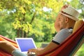 Young man with laptop resting in comfortable hammock Royalty Free Stock Photo