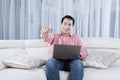 Young man with laptop shows OK gesture Royalty Free Stock Photo