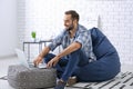 Young man with laptop sitting on beanbag chair at home Royalty Free Stock Photo