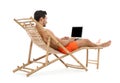 Young man with laptop on sun lounger against white . Beach accessories Royalty Free Stock Photo