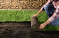 Young man laying grass sod on ground at backyard. Space for text Royalty Free Stock Photo