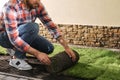 Young man laying grass sod on ground at backyard, closeup. Space for text Royalty Free Stock Photo