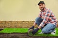 Young man laying grass sod on ground at backyard, space for text Royalty Free Stock Photo