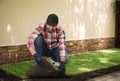 Young man laying grass sod on ground at backyard Royalty Free Stock Photo