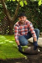 Young man laying grass sod on ground Royalty Free Stock Photo